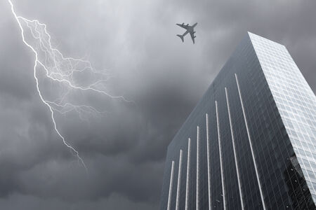 Bottom view of airplane flying above skyscrapersの写真素材