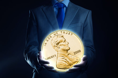 Businessman holding huge cent coin in hand