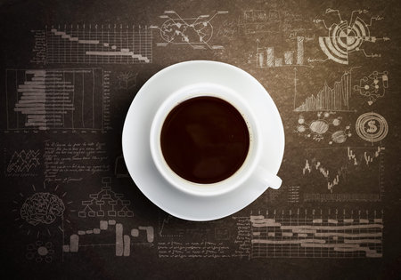 Close up of cup of coffee on table with sketches on backgroundの写真素材