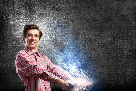 Young man looking shocked in tablet pcの写真素材