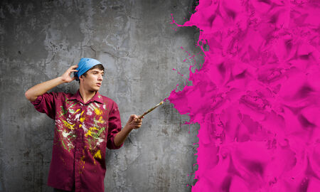 Young handsome man painter with brush in handの写真素材