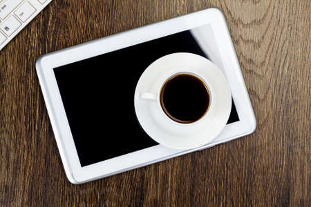 Tablet pc cup of coffee and keyboard on tableの写真素材