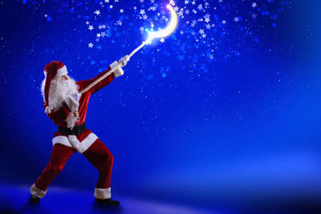 Santa Clause in red costume against blue backgroundの写真素材