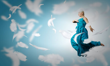 Young attractive woman in blue dress jumping highの写真素材