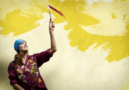 Young woman painter in bandana with paintbrush in handの写真素材