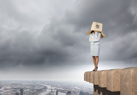 Businesswoman in suit wearing carton box on headの写真素材