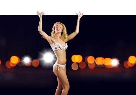 Attractive girl in swimming suit with white blank banner  Place for textの写真素材