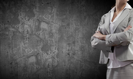 Chest view of businesswoman standing against cement wallの写真素材