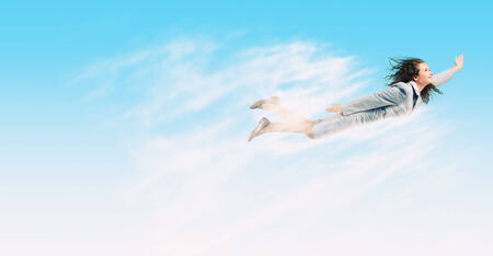 Young determined businesswoman flying high in skyの写真素材