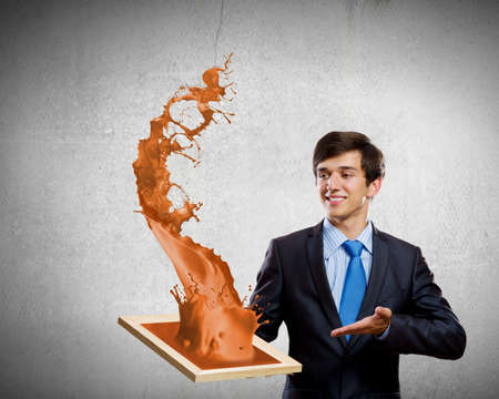 Handsome businessman holding frame with colorful splashesの写真素材