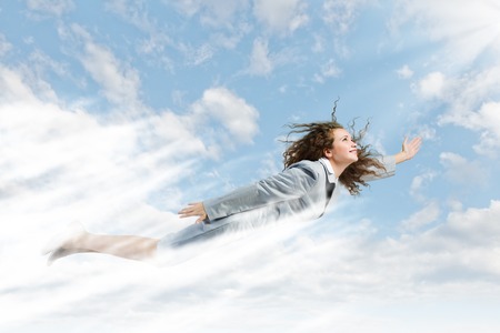 Young determined businesswoman flying high in skyの写真素材