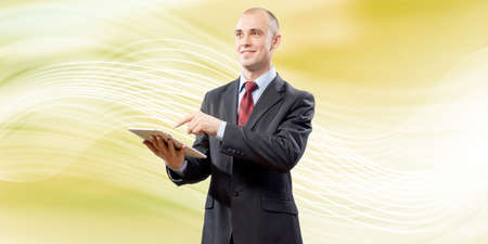 Young handsome businessman holding tablet pc in handの写真素材