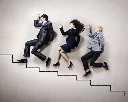 Young people in business suits lying on floorの写真素材