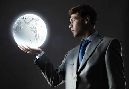 Young businessman holding moon planet in handの写真素材