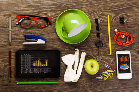 Tablet pc mobile phone and stationary items on wooden table