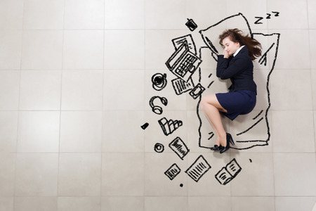 Top view of young tired sleeping businesswomanの写真素材