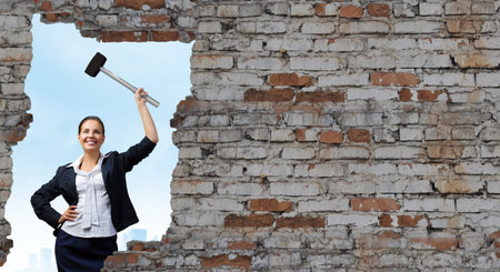 Young attractive businesswoman with hammer in handsの写真素材