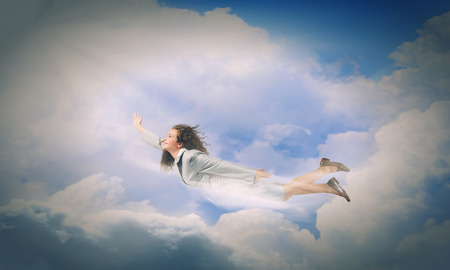 Young determined businesswoman flying high in skyの写真素材