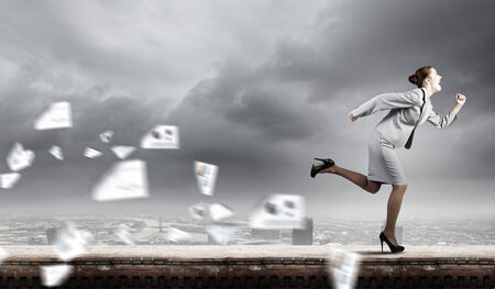 Young businesswoman in suit running in a hurryの写真素材