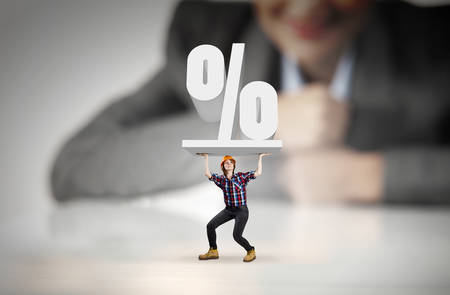 Businesswoman looking at miniature of woman engineerの写真素材