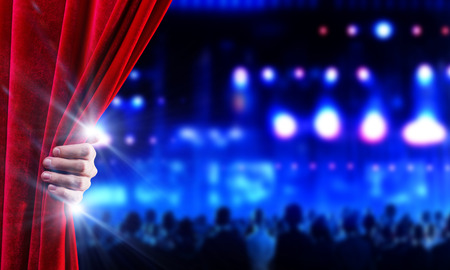 Hand of businessman opening red velvet curtainの写真素材