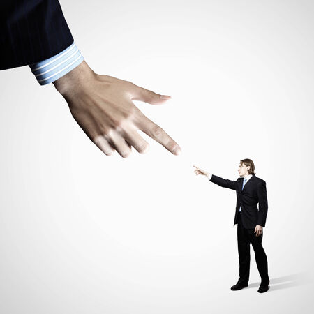 Close up of male businessman pointing at miniature of manの写真素材