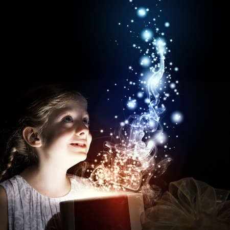 Little cute girl opening Christmas gift boxの写真素材