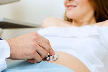 Young pregnant woman examined by doctor at ultrasound check