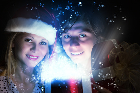 Happy family of man and woman opening Christmas giftsの写真素材