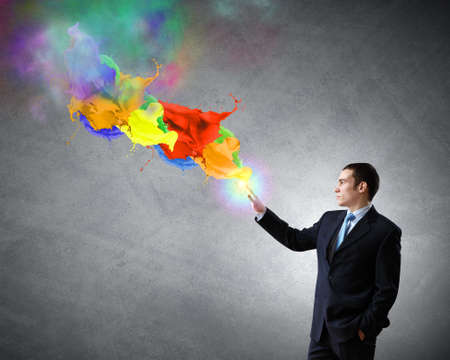 Young businessman in suit and colorful splashesの写真素材