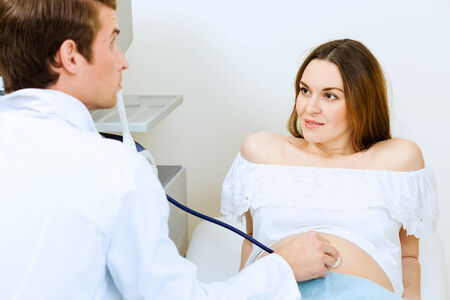Young pregnant woman examined by doctor at ultrasound checkの写真素材
