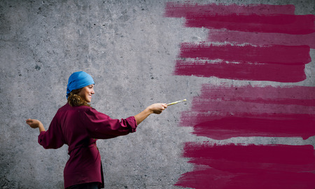 Young girl painter with brush wearing bandanaの写真素材