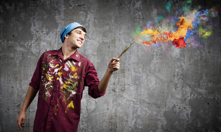 Young handsome man painter with brush in handの写真素材