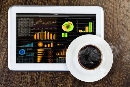 Tablet pc cup of coffee and notepad at tableの写真素材