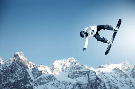 Snowboarder making jump high in clear skyの写真素材