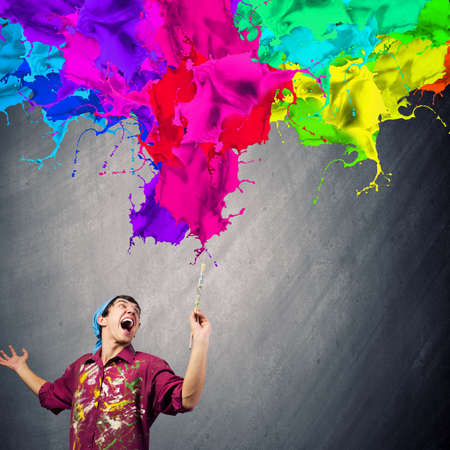 Young handsome man painter with brush in handの写真素材