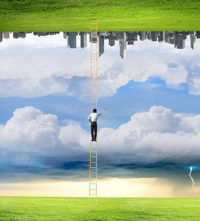 Businessman standing on ladder between two realitiesの写真素材