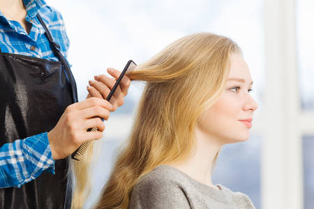 Young woman in chair at barbers and hairdresserの写真素材