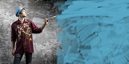 Young handsome man painter with brush in handの写真素材