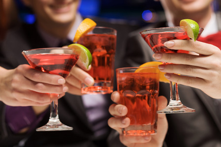 Young attractive people of four having cocktail partyの写真素材