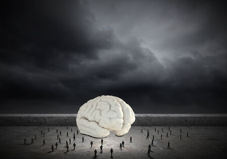 Huge human brain and many little businesspeople aroundの写真素材