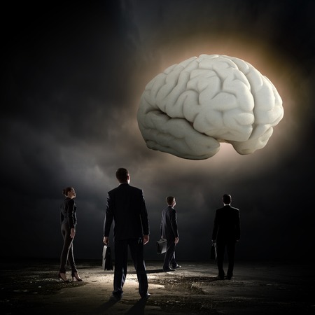 Huge human brain and many little businesspeople aroundの写真素材