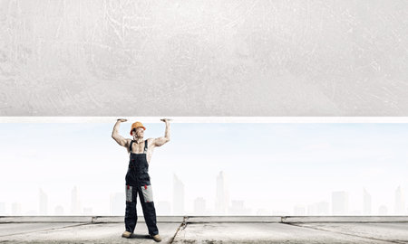 Strong man in uniform lifting wall above head