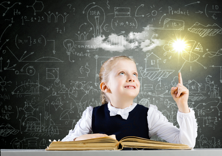 Foto de Schoolgirl at lesson with opened book against sketch background - Imagen libre de derechos