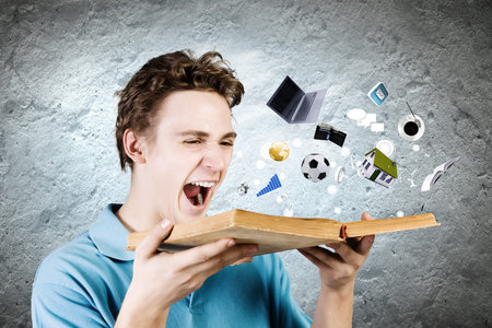 Young man in casual holding opened book with icons flying out