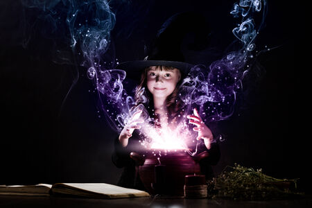 Little Halloween witch reading conjure above potの写真素材