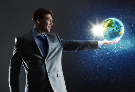 Young businessman holding Earth planet in hand  の写真素材