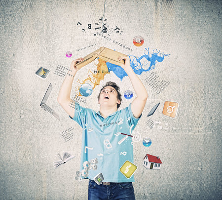 Young man in casual holding opened book with icons flying out