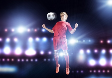 Young football player on stadium kicking ballの写真素材