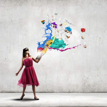 Woman in red dress with book in handsの写真素材